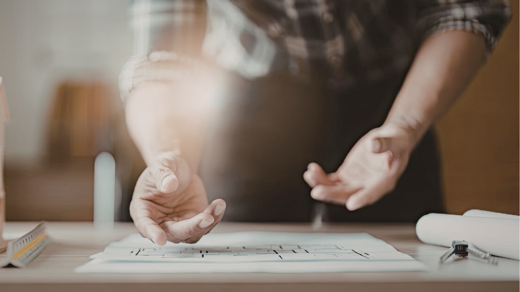homeowner planning a home remodel with blueprints notebook calculator and tape measure