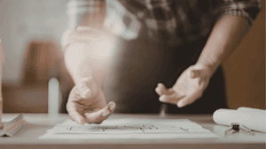 homeowner planning a home remodel with blueprints notebook calculator and tape measure